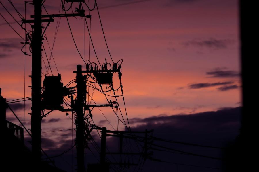 Power outage in Portland with electrical tower in foreground and sunset in background
