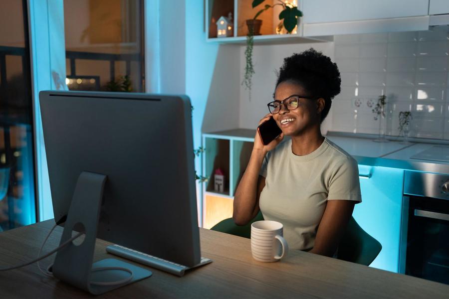 Woman in her kitchen at her laptop calling a technician