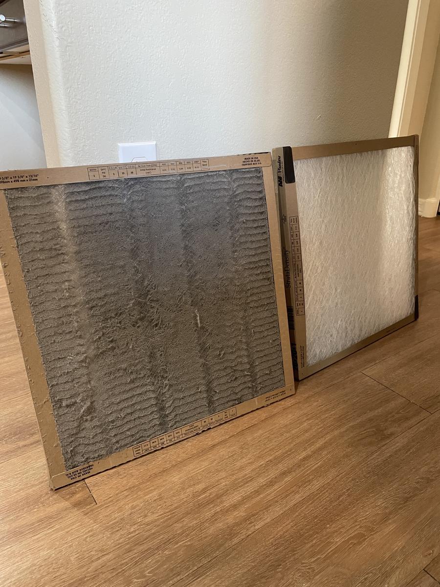 A dirty square air filter sitting next to a clean square air filter